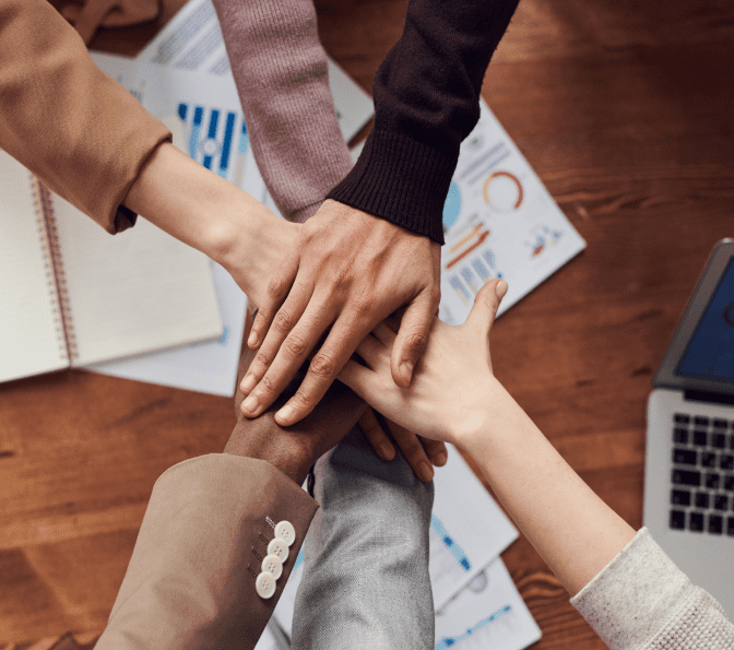 A group of people holding hands on top of each other.