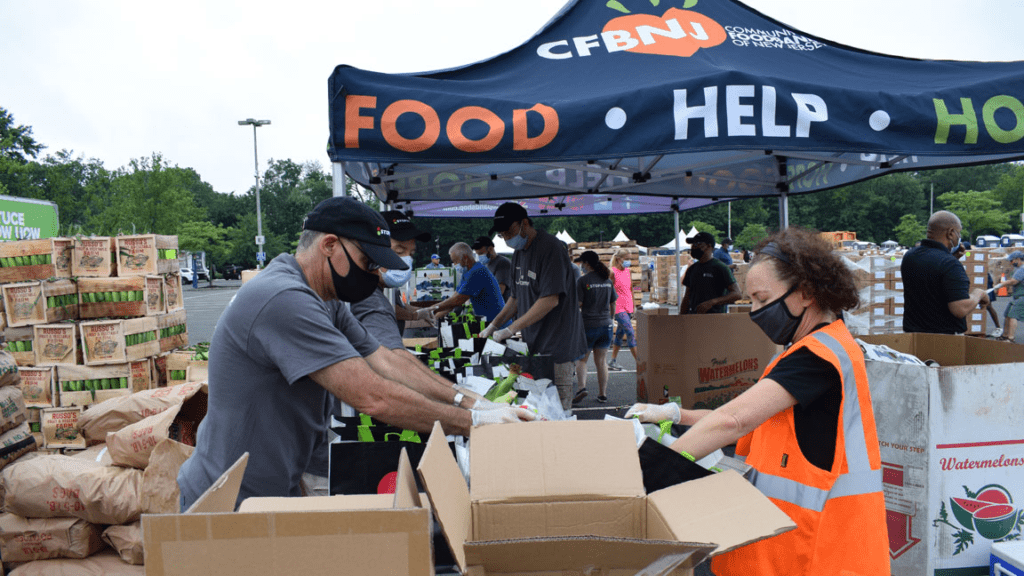 A man and woman are handing out boxes of food.