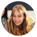 A girl with long hair smiles for the camera.