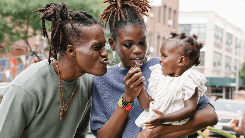 A group of people with dreadlocks are holding a baby.