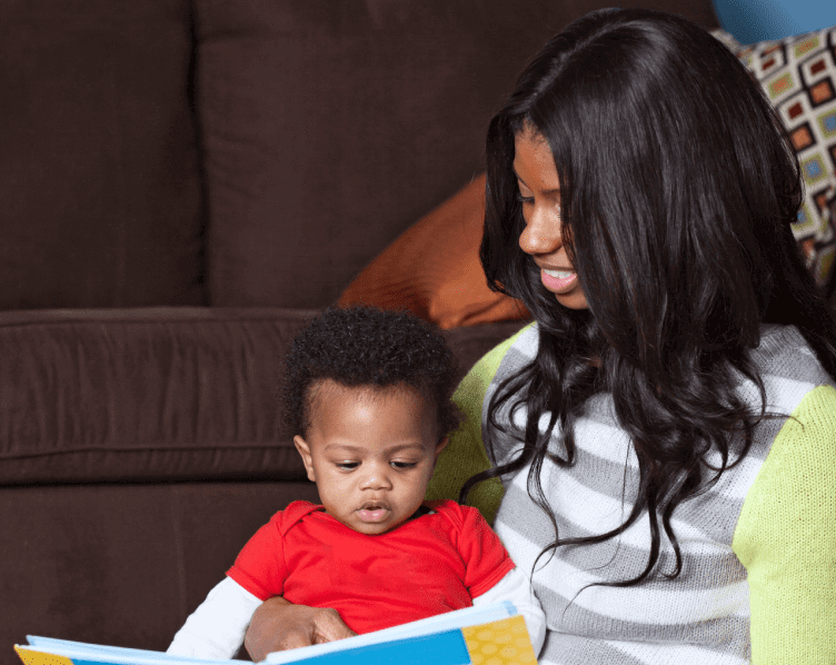 A woman and child reading a book together.