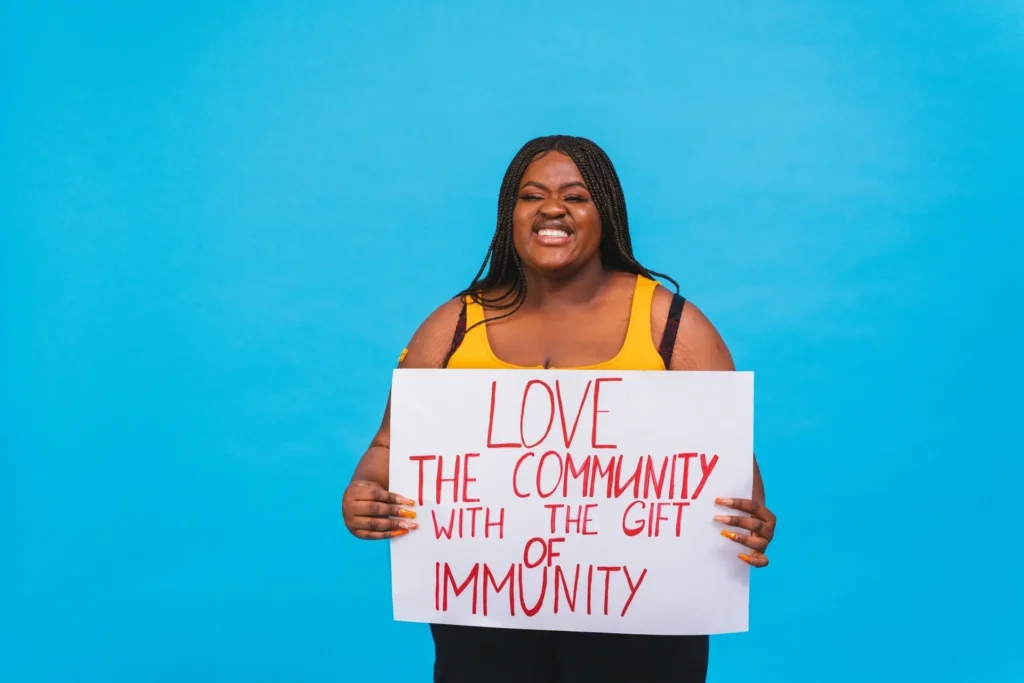 Woman holding sign promoting community immunity.